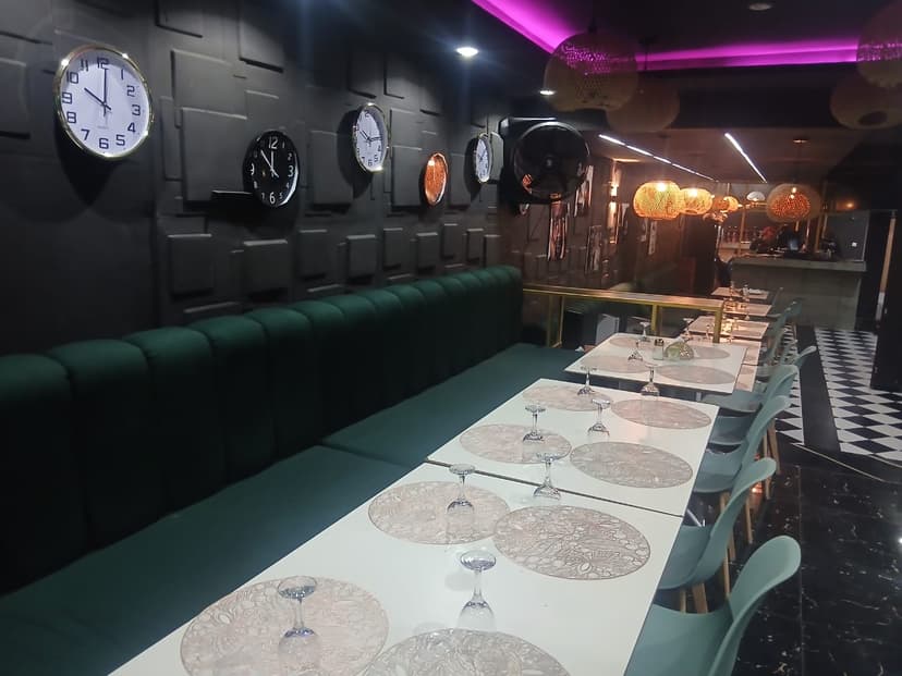 Le mur d'horloges et le néon magenta au plafond