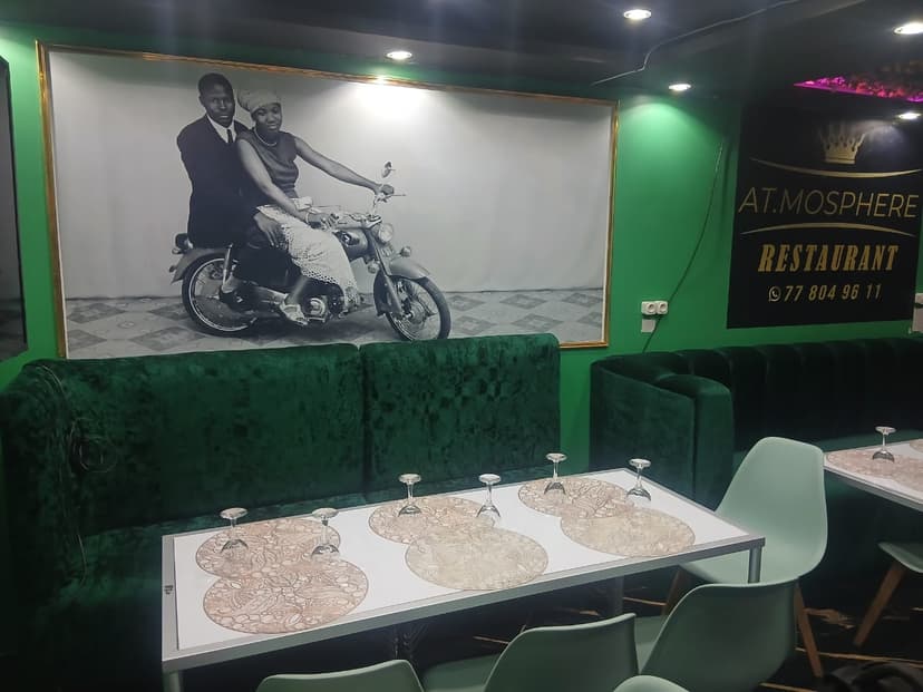 Banquettes de velours vert sous un grand portrait en noir et blanc